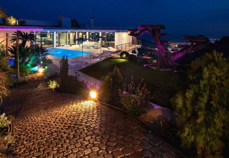 Villa éclairée ña nuit avec jardin